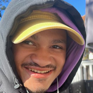 Bashir smiling in his yellow cap