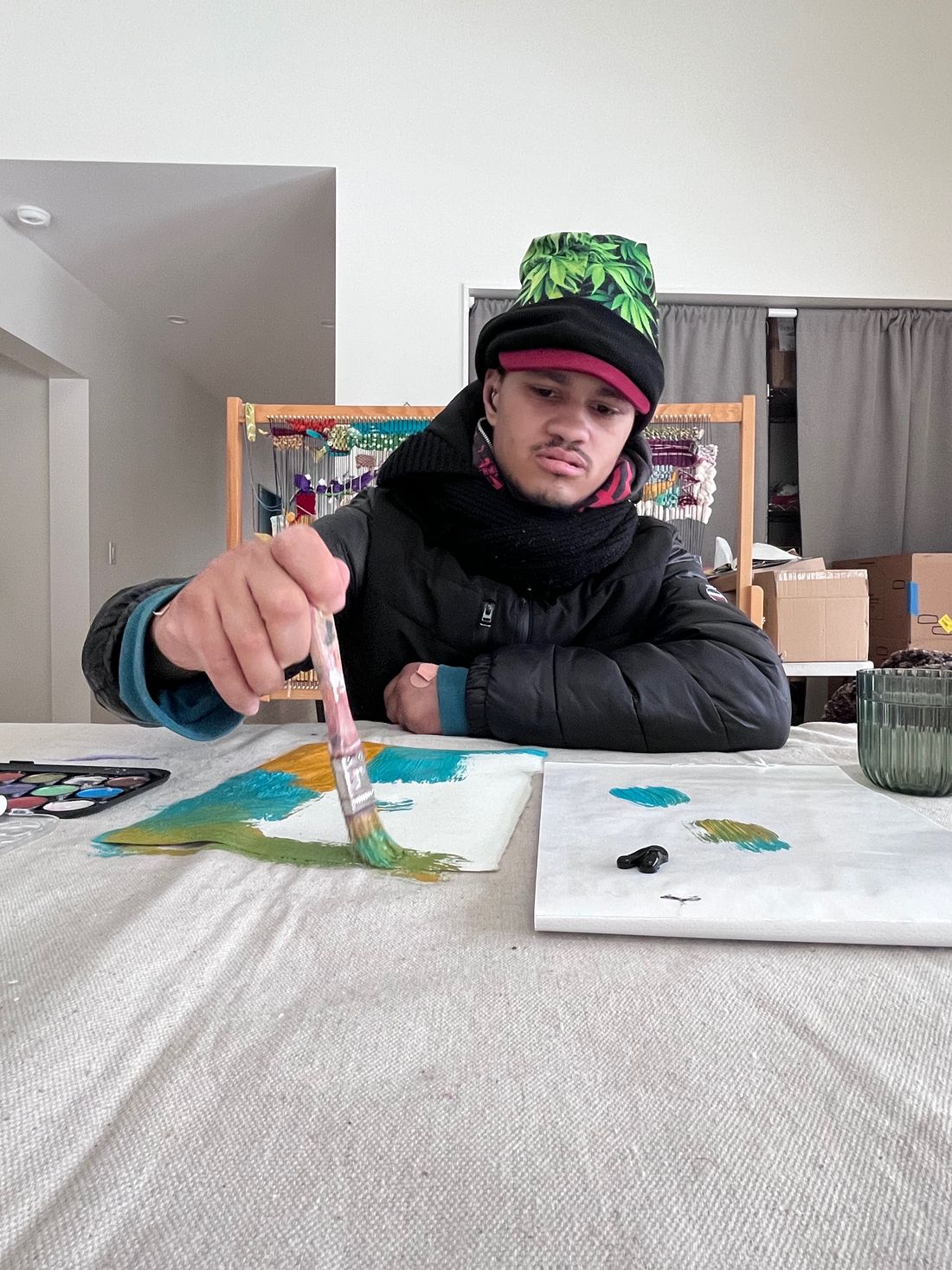 Bashir at a table, brush in hand, painting in watercolor.